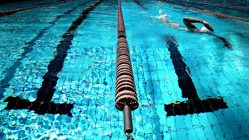 Swimmer in Pool Lane with Blue Water Ripples