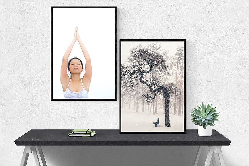Minimalist interior with framed yoga and winter tree art on a black console table