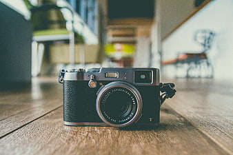 Vintage Black Camera on Wooden Table with Blurred Background