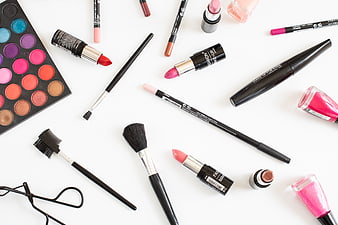 Flat lay of colorful makeup products and brushes on white background