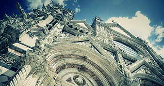 Low angle view of ornate cathedral facade against blue sky