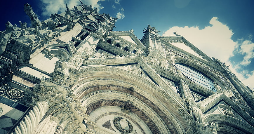 Low angle view of ornate cathedral facade against blue sky
