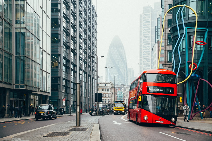 Red Double-Decker Bus on London Street with Gherkin