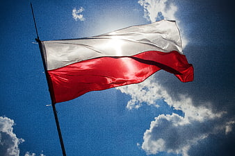 Polish flag waving against blue sky with clouds