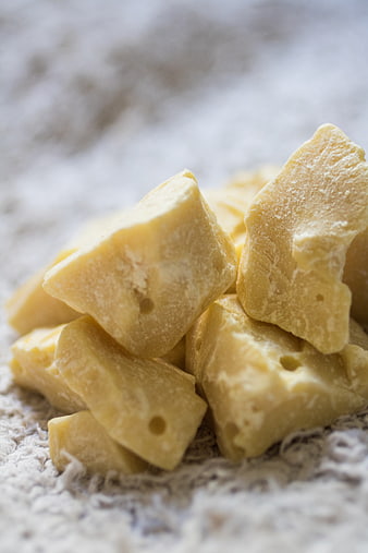 Raw Cocoa Butter Chunks on Textured White Fabric