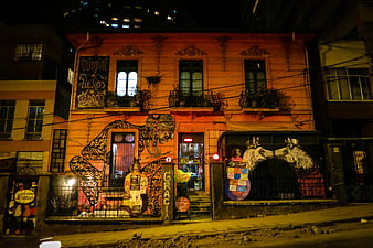 Colorful Graffiti Mural on Orange Building at Night