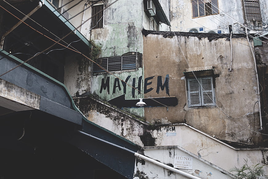 Weathered Urban Building Facade With Mayhem Graffiti And Street Sign