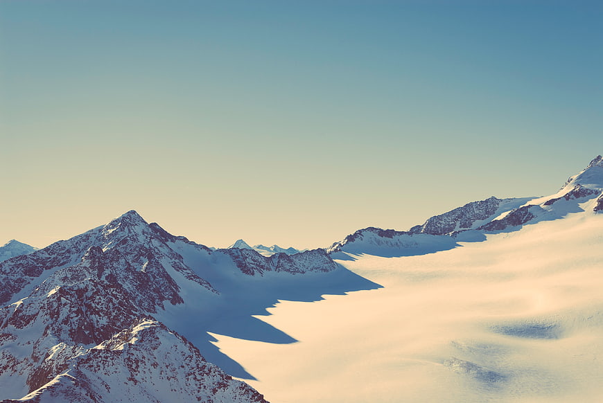 Snowy Mountain Peaks Above Sea of Clouds