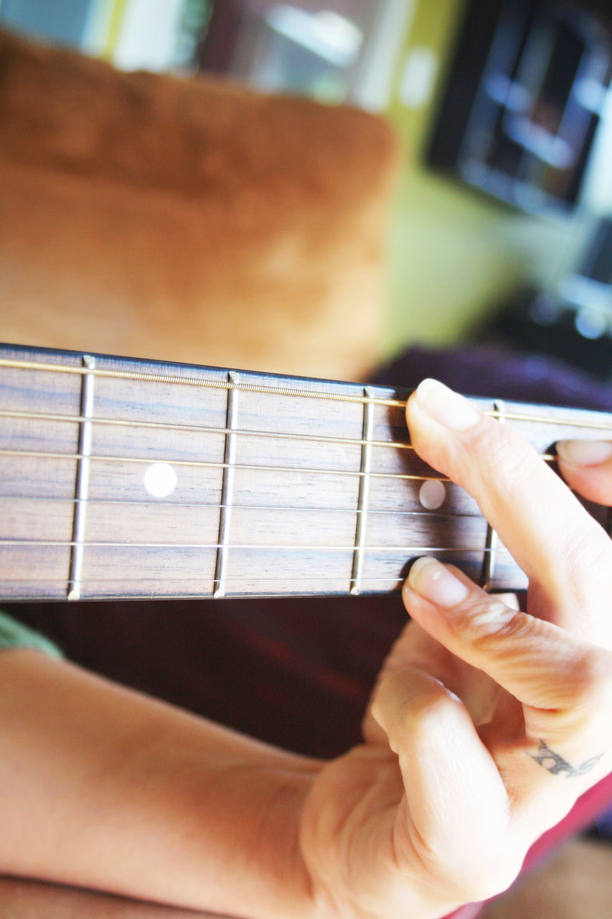 Close-up of hand playing acoustic guitar chords