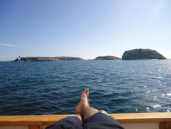 Relaxing on a boat with feet up overlooking ocean islands