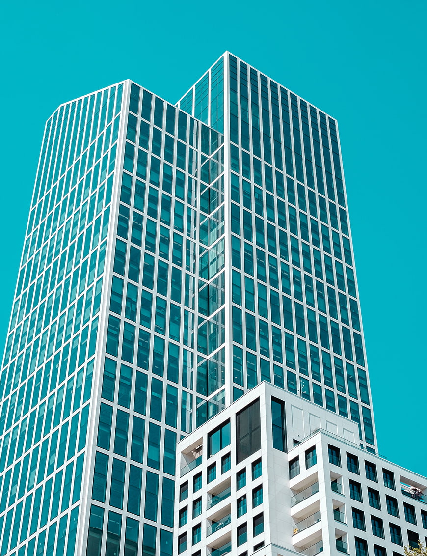 Modern Glass Skyscraper Against Vibrant Teal Sky
