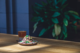 Colorful salad and iced coffee on wooden table with sunlight