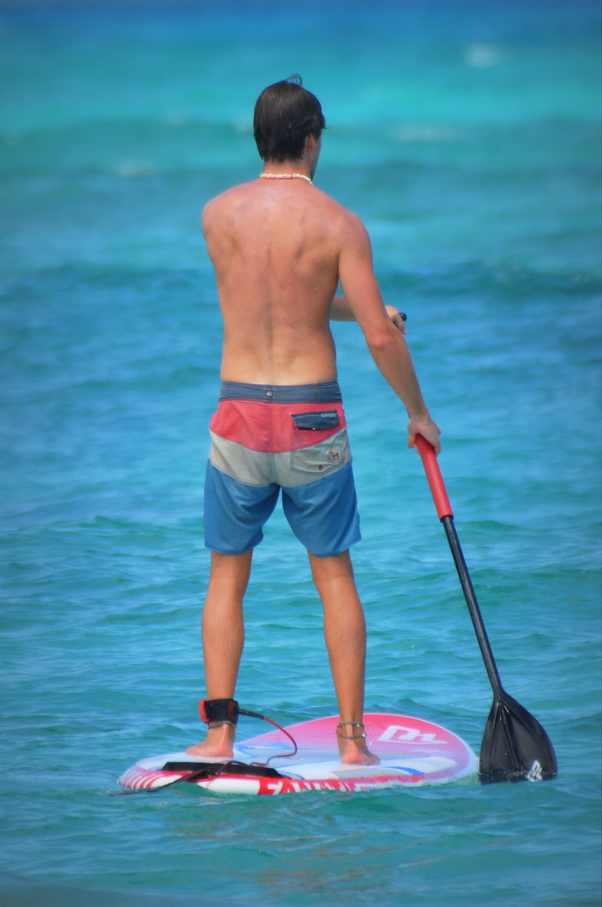 Man Paddleboarding on Turquoise Ocean Water