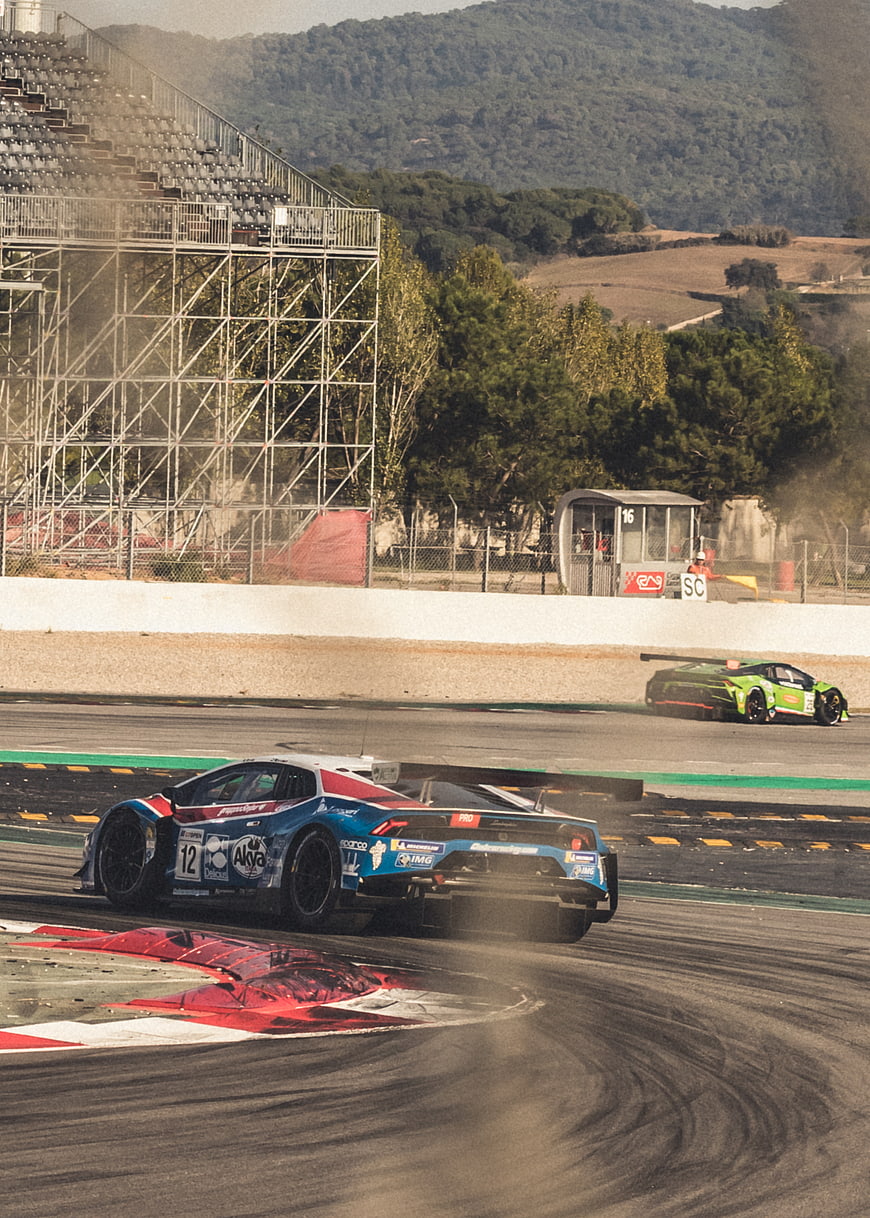 Blue racing car drifting on track with green car in background
