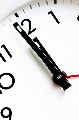 Close-up of white analog clock face with black hands