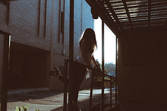 Silhouette of Woman Stretching on Staircase in Sunlight