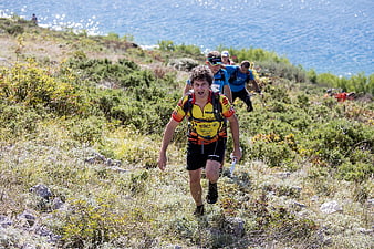 Male Trail Runner Sprinting Uphill Near Ocean Coast