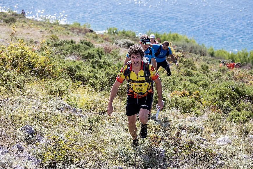 Male Trail Runner Sprinting Uphill Near Ocean Coast