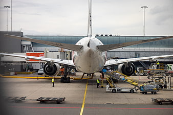 Rear view of commercial airplane being serviced at airport terminal