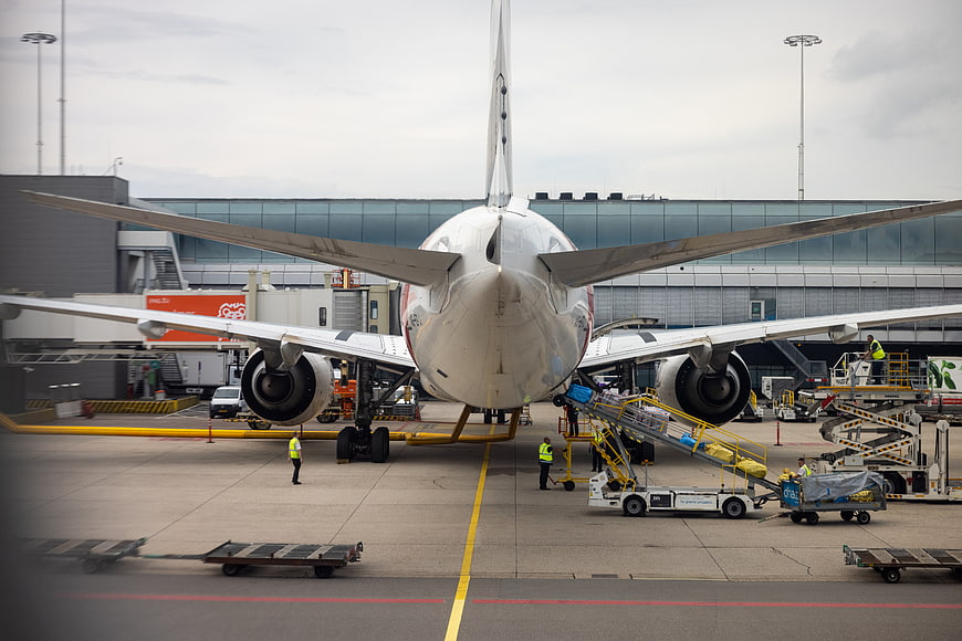 Rear view of commercial airplane being serviced at airport terminal