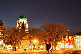 Night view of illuminated city square with people walking