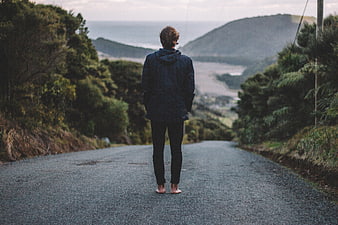 Man Standing Barefoot on Road Looking at Ocean View
