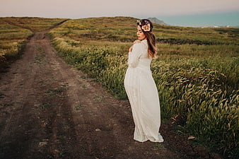 Woman in White Dress Standing on Dirt Road in Field
