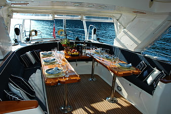 Luxury yacht dining area with wooden table and ocean view