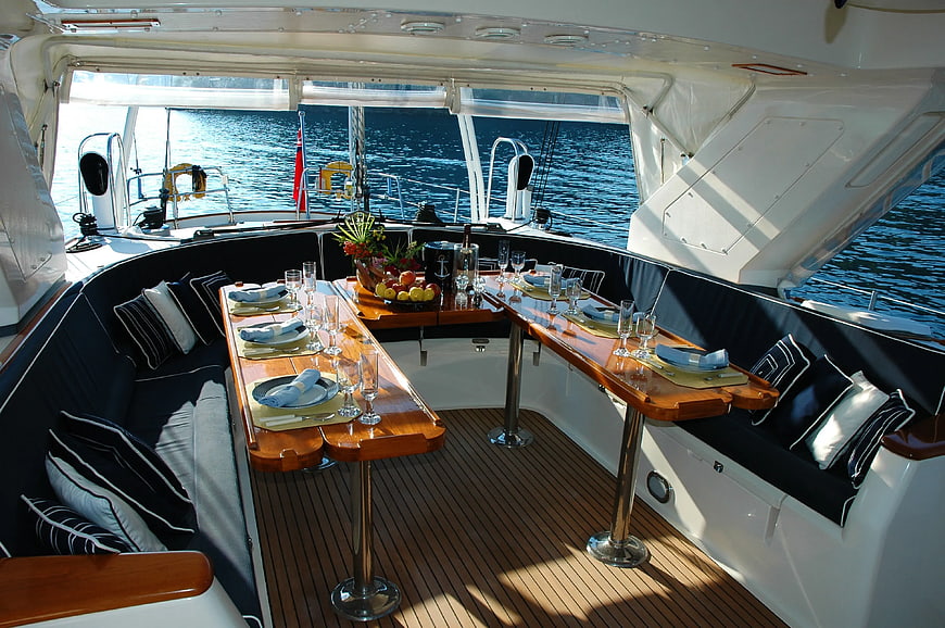 Luxury yacht dining area with wooden table and ocean view