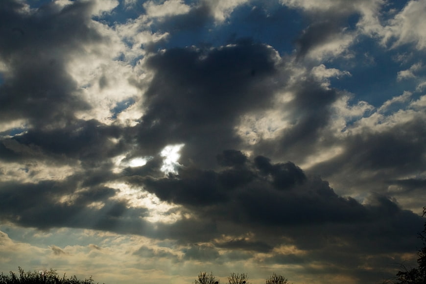 Dramatic dark clouds with sun rays breaking through