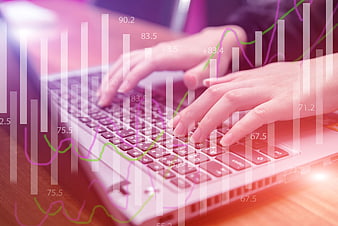 Hands typing on laptop with financial data overlay