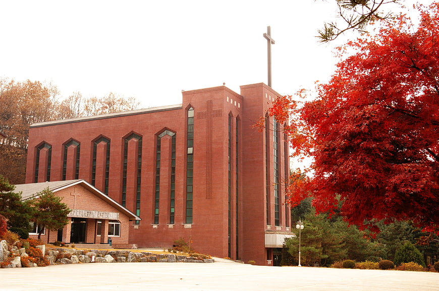 Red brick church with cross in autumn landscape