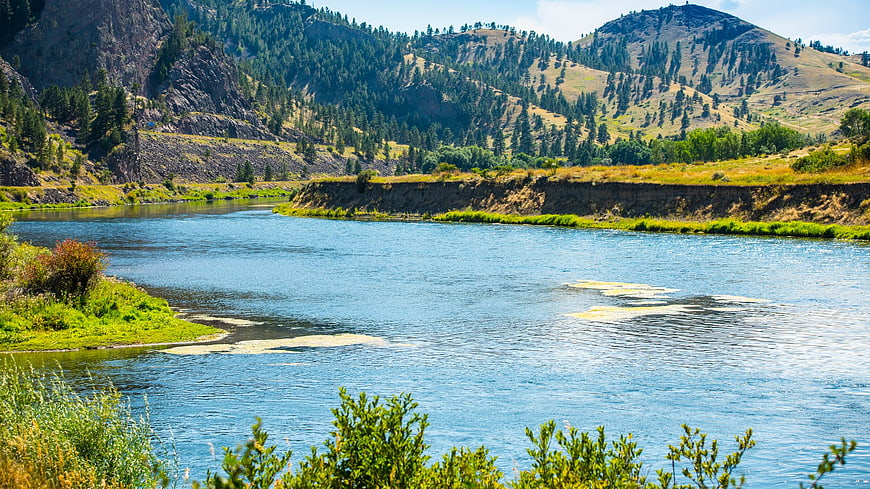 Scenic river flowing through mountain valley with green hills