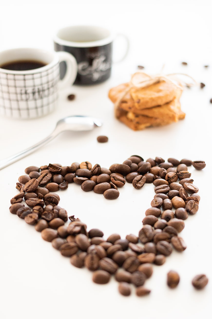Coffee beans heart shape with mugs and cookies