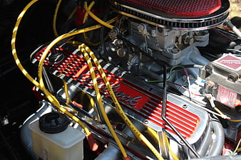 Close-up of classic red and chrome car engine with yellow wires