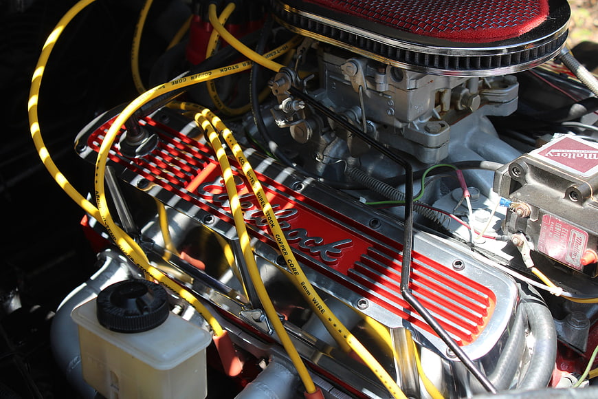 Close-up of classic red and chrome car engine with yellow wires