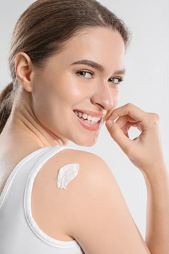 Smiling Woman with Skincare Cream on Shoulder