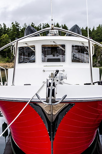 Front view of red and white boat docked in calm water