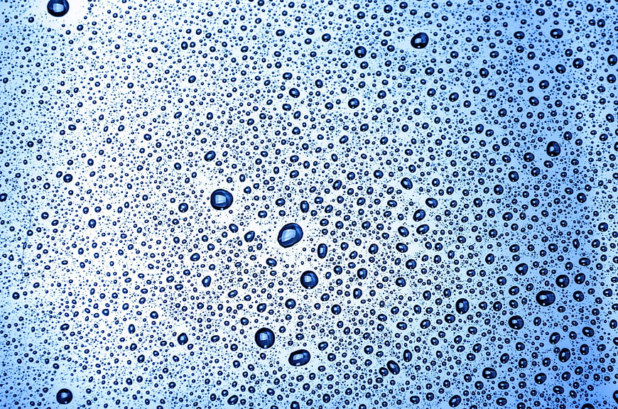 Blue water droplets on glass background texture