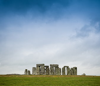 Stonehenge monument on green field under blue sky