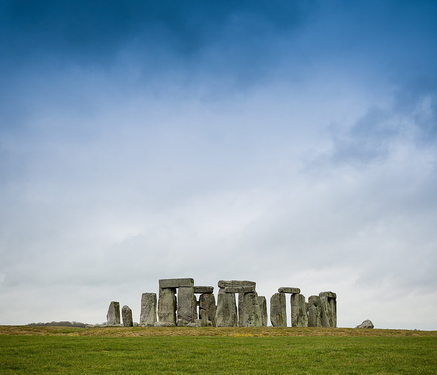 Stonehenge monument on green field under blue sky