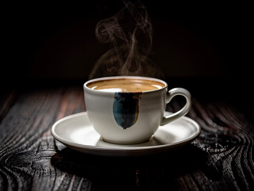 Steaming Hot Coffee in Artisan Ceramic Cup on Dark Wood