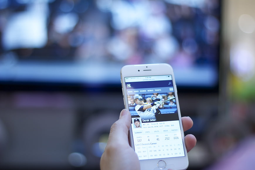Hand holding smartphone displaying baseball player stats