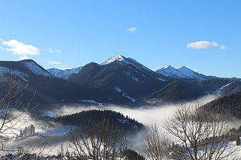 Snowy Mountain Peaks Rising Above Valley Fog