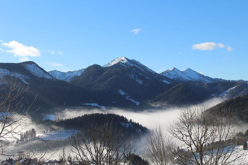 Snowy Mountain Peaks Rising Above Valley Fog