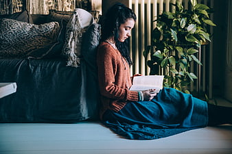Woman Reading Book on Floor in Cozy Living Room