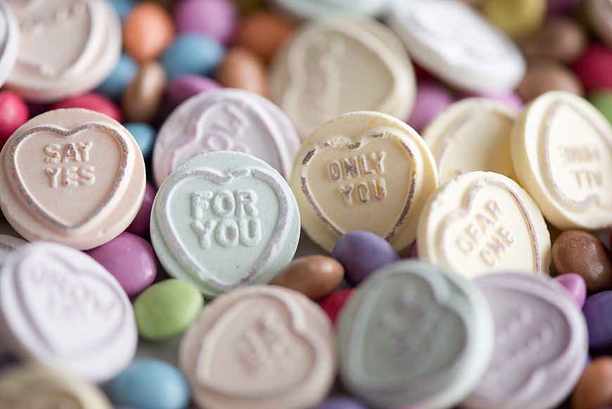 Close-up of pastel conversation hearts and colorful candies