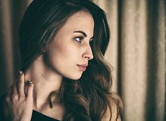 Contemplative Woman Touching Neck in Profile