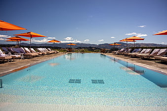 Luxury Resort Pool with Orange Umbrellas and Mountain View