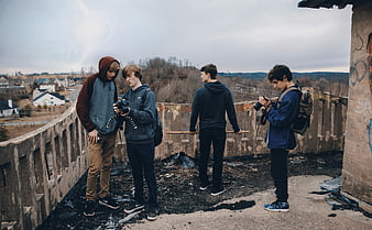 Young men exploring abandoned building with cameras